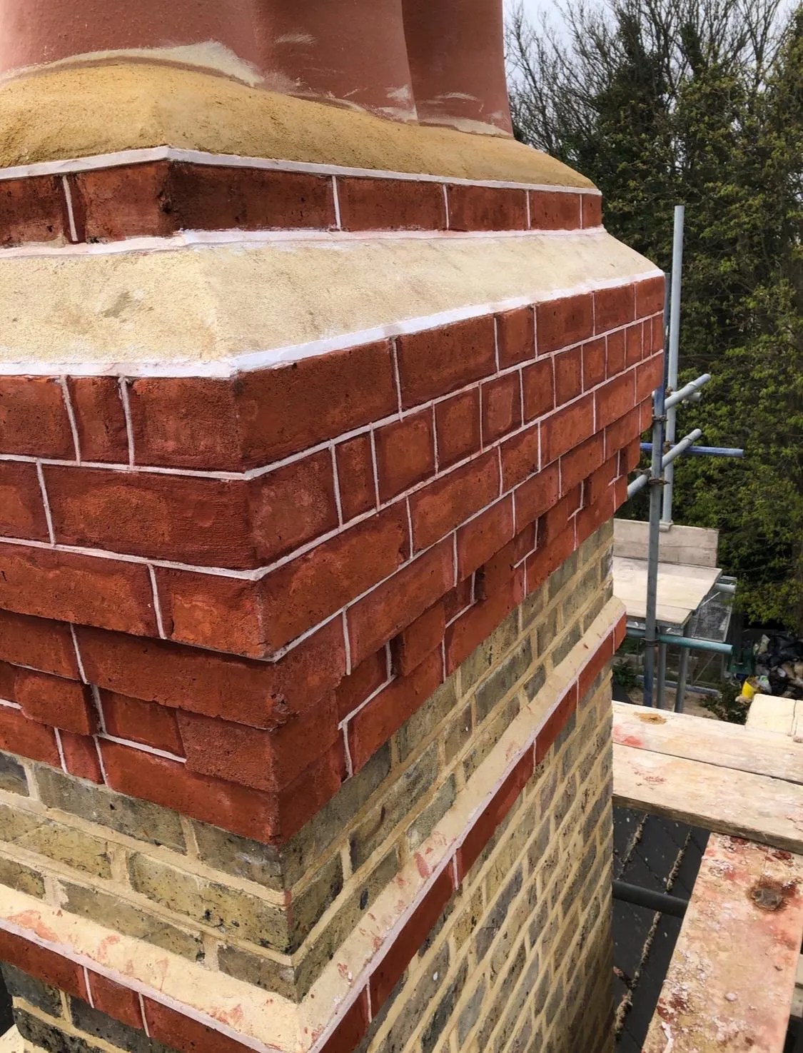 Restored Victorian chimney stack with fine tuck-pointed mortar lines and a new sandstone cap